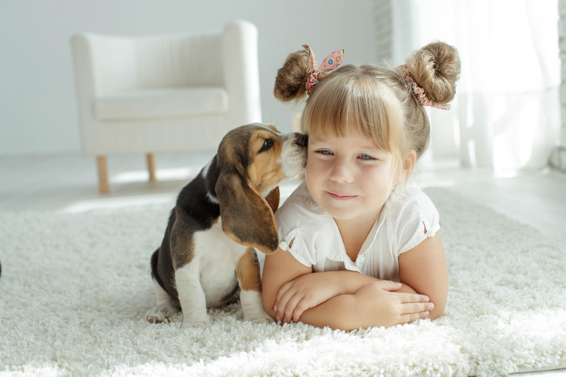 Girl on carpet with a puppy