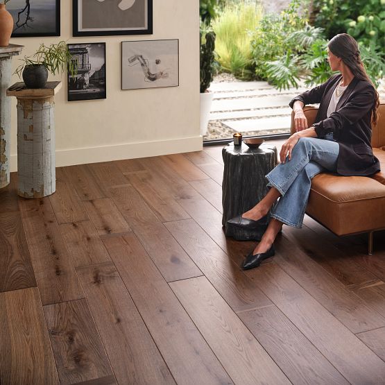 Hardwood flooring in living room with woman on a couch