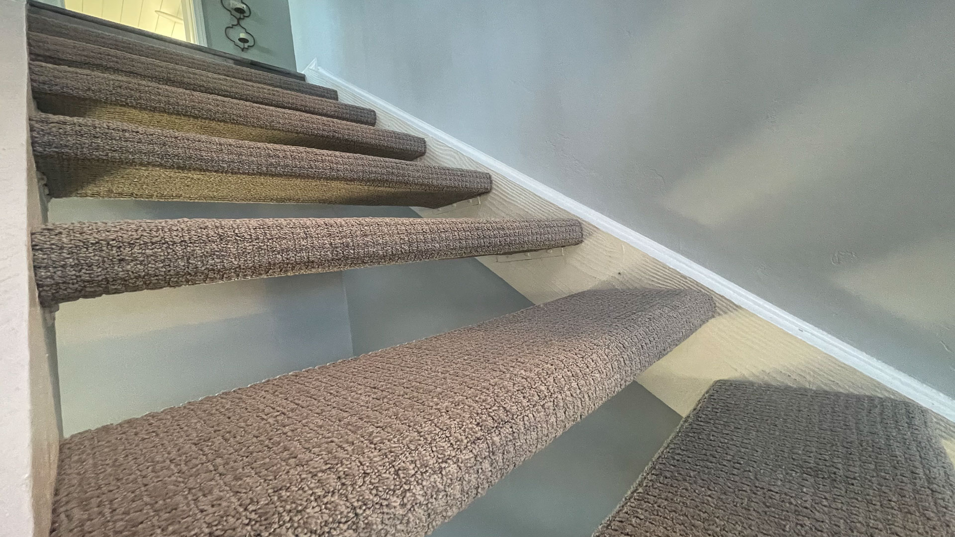 Close-up view of wrap-around carpet on stairs